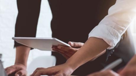 Ansicht von Händen mehrerer Menschen an einem Schreibtisch